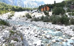 A stone river with a nice background and a brown house in the back.