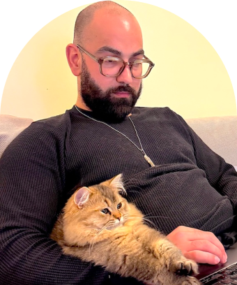 image of ferkan with katmer, british long hair cat, on his lap working on a laptop